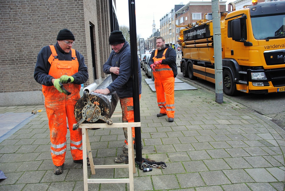 Zwarte koker met wieltje verdwijnt onder de grond