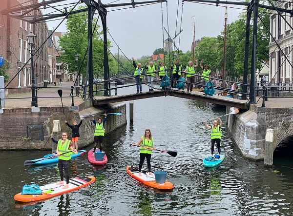 Rotary ruimt plastic rommel op straat, park en water op
