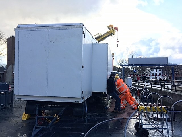 Bergingsbedrijf bezig met afvoer oliebollenkraam op Koemarkt