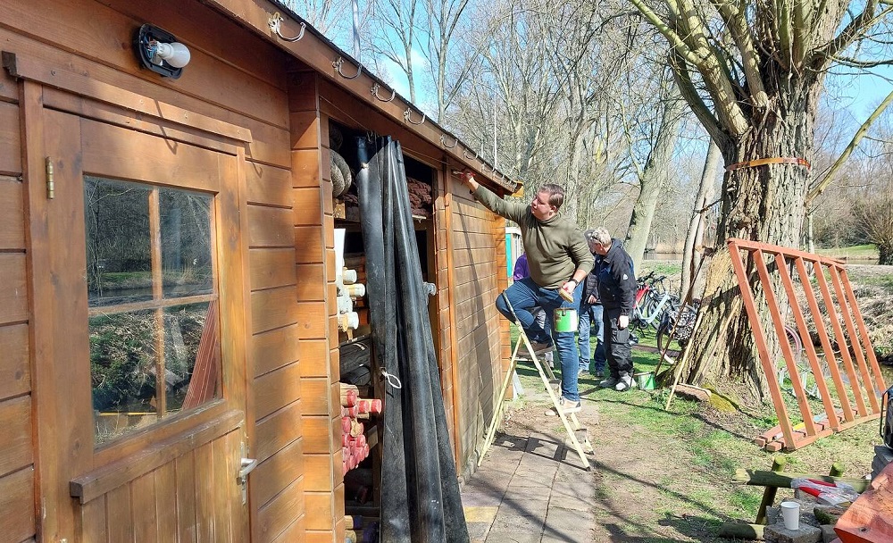 Vrijwilligers verven de schuur bij  Scouting Aleida