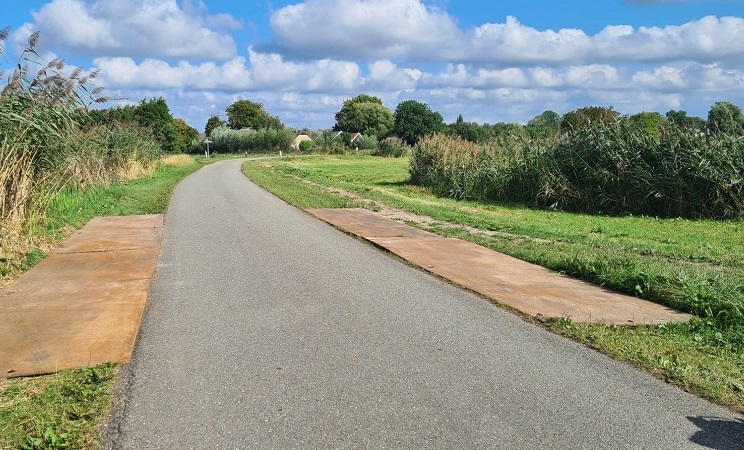 Er liggen al rijplaten op fietspad waarover auto's gaan rijden