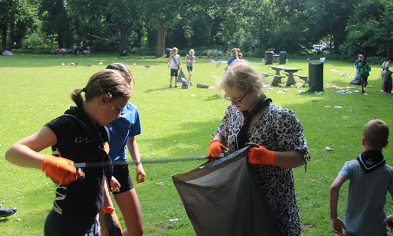 Welpen van Scouting Tono-groep prikken afval in het park